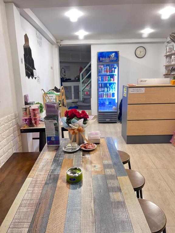 a room with a table with flowers and a refrigerator at THE JOYS HOSTEL in Ho Chi Minh City
