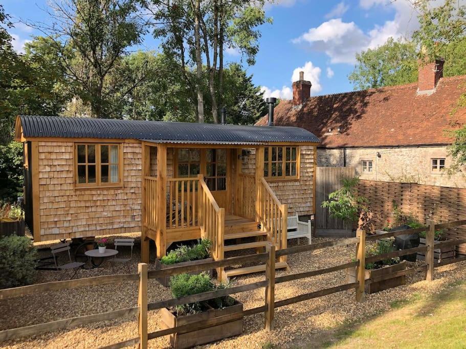 a log cabin with a deck and a house at The Walnut Wagon in the heart of Mells. in Frome