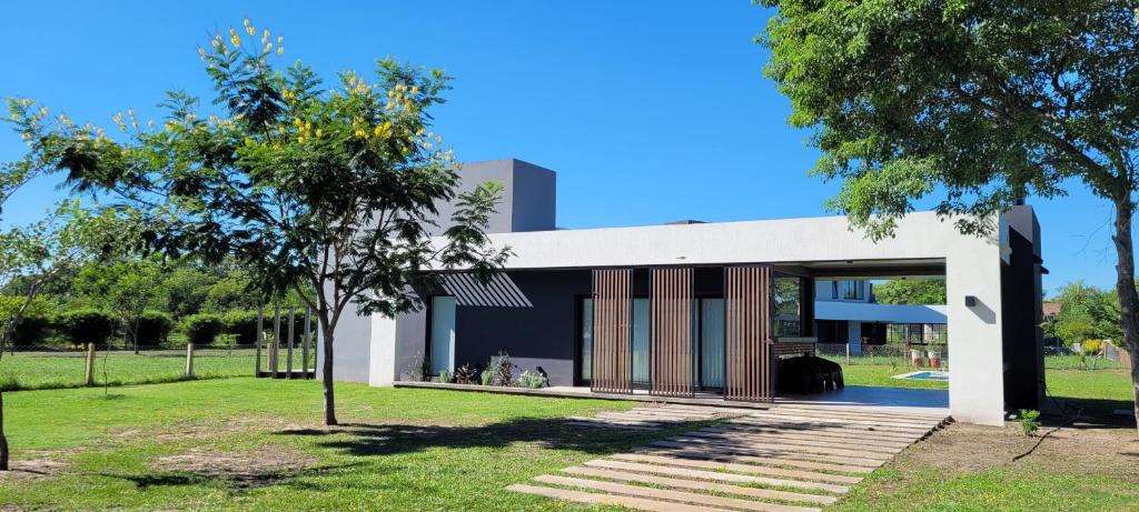 una casa moderna en un parque con un árbol en Guyra, Casas Boutique en Corrientes