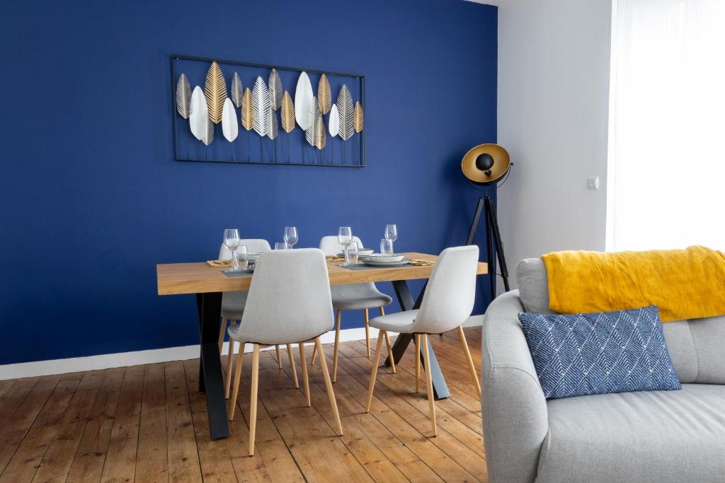 ein Esszimmer mit einem Tisch und einer blauen Wand in der Unterkunft Appartement spacieux in Quimper