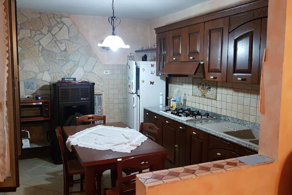 une cuisine avec des placards en bois et une table avec une table dans l'établissement A Casa Di Elena, à Colleferro