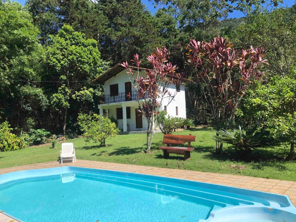 una piscina frente a una casa en Casa em Friburgo com piscina lareira suíte & quarto en Nova Friburgo