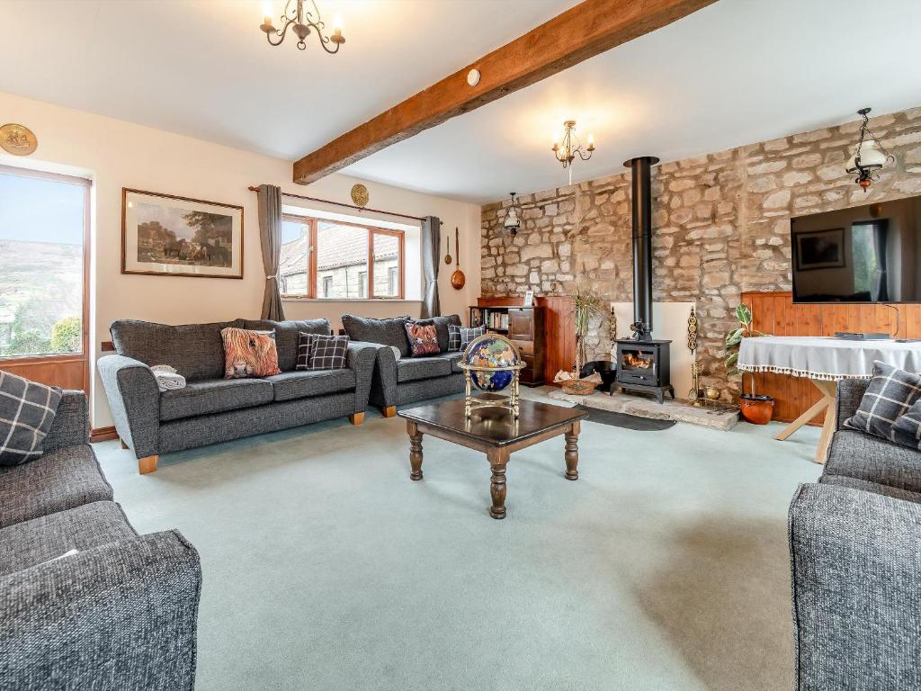 a living room with couches and a stone wall at The Haybarn - Uk42935 in Rosedale Abbey