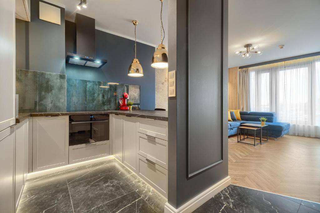 uma cozinha com armários brancos e uma sala de estar em Margi Whisky Apartament LUX AIRCON em Szczecin