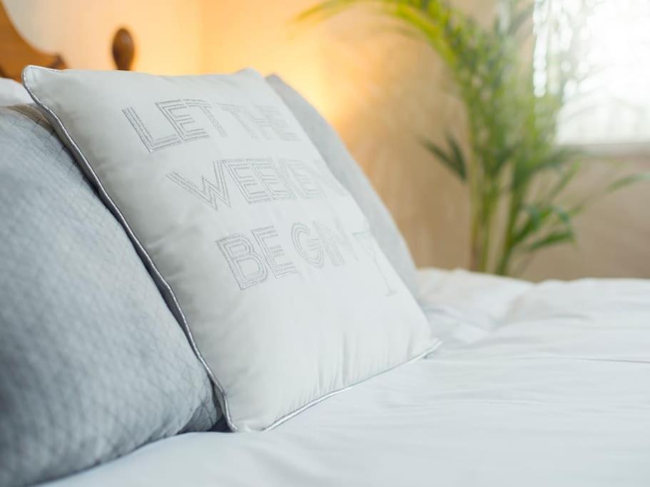 uma almofada branca numa cama com almofadas cinzentas em Tŷ Summerfield by Dream Short Stays em Cardiff