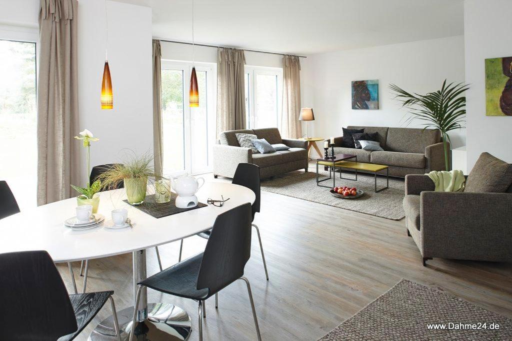 ein Wohnzimmer mit einem weißen Tisch und Stühlen in der Unterkunft 1902 - Am Kurpark in Dahme