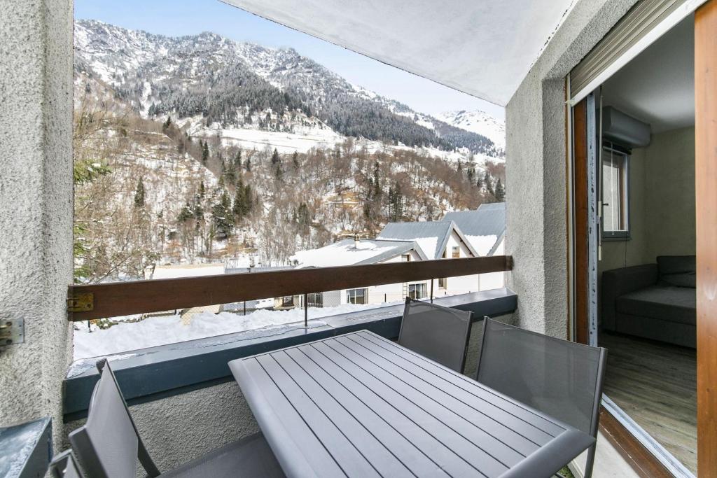 a balcony with a table and a view of a mountain at L'Esquiròu - Proche pistes pour 6 in Barèges