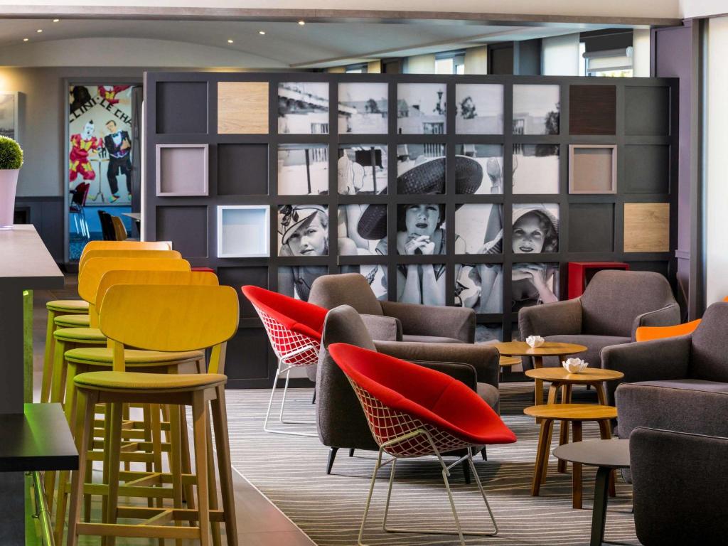 a lobby with colorful chairs and tables at Mercure Honfleur in Honfleur