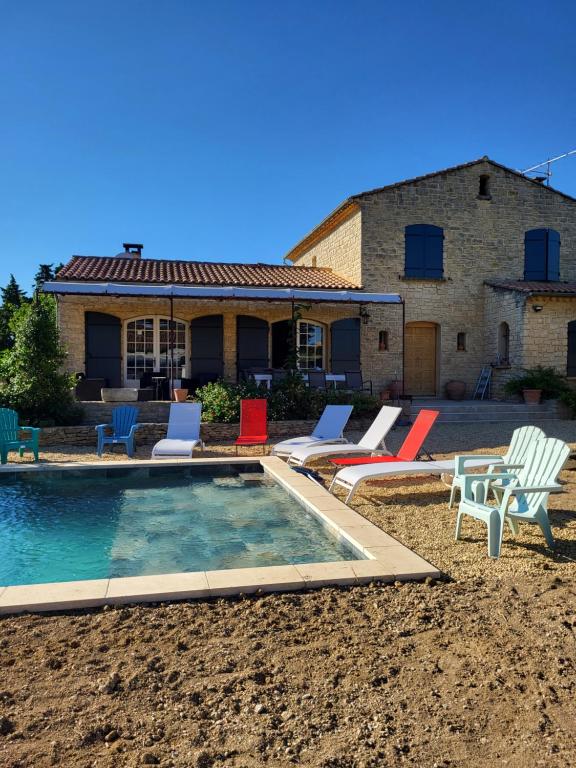 una casa con una piscina con sillas y una casa en Villa gitedelea, en Aubignan