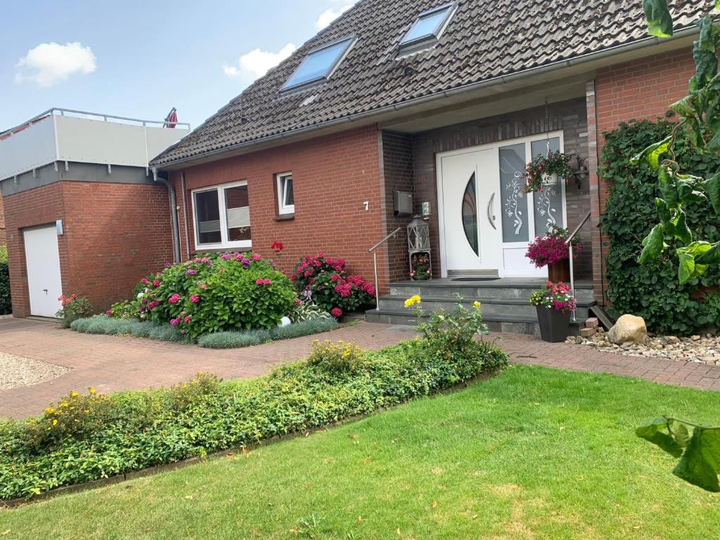 a brick house with flowers in the front yard at Ferienwohnung Novotny in Jerrishoe