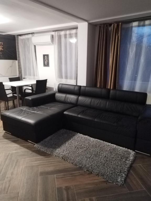 - un canapé en cuir noir dans un salon avec une table dans l'établissement Ultracentral Apartment Villa ELENA Palas Mall, à Iaşi