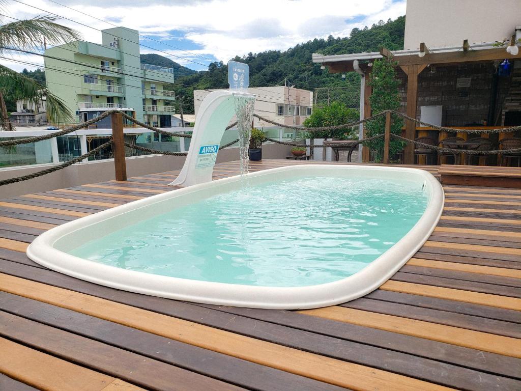 una bañera de hidromasaje en una terraza con una fuente de agua en Hospedagem 3 Estrelas, en Navegantes