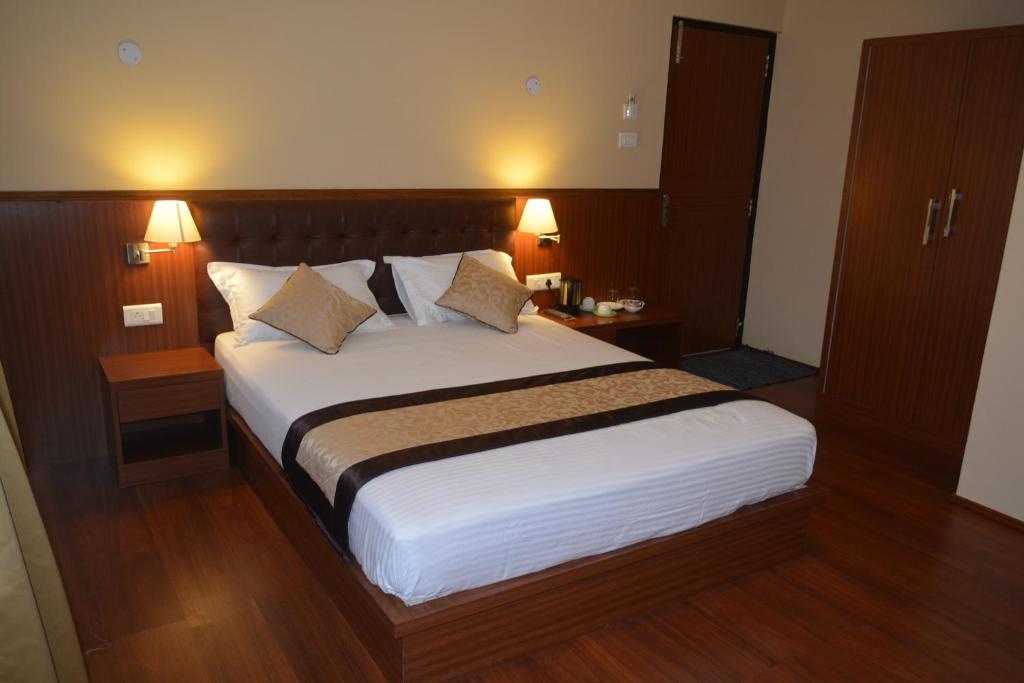 Juniper Residency Hotel tesisinde bir odada yatak veya yataklar