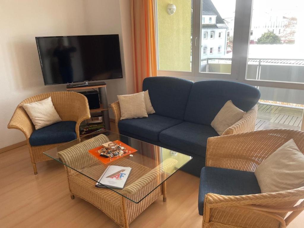 a living room with a couch and chairs and a tv at Likedeeler Weg 1 Whg 21 in Zingst