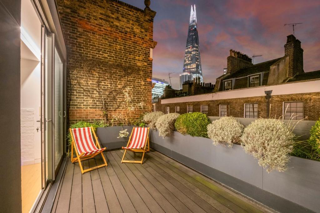 two chairs on a balcony with a view of the shard at A Starry Starry Night - Borough - by Frankie Says in London