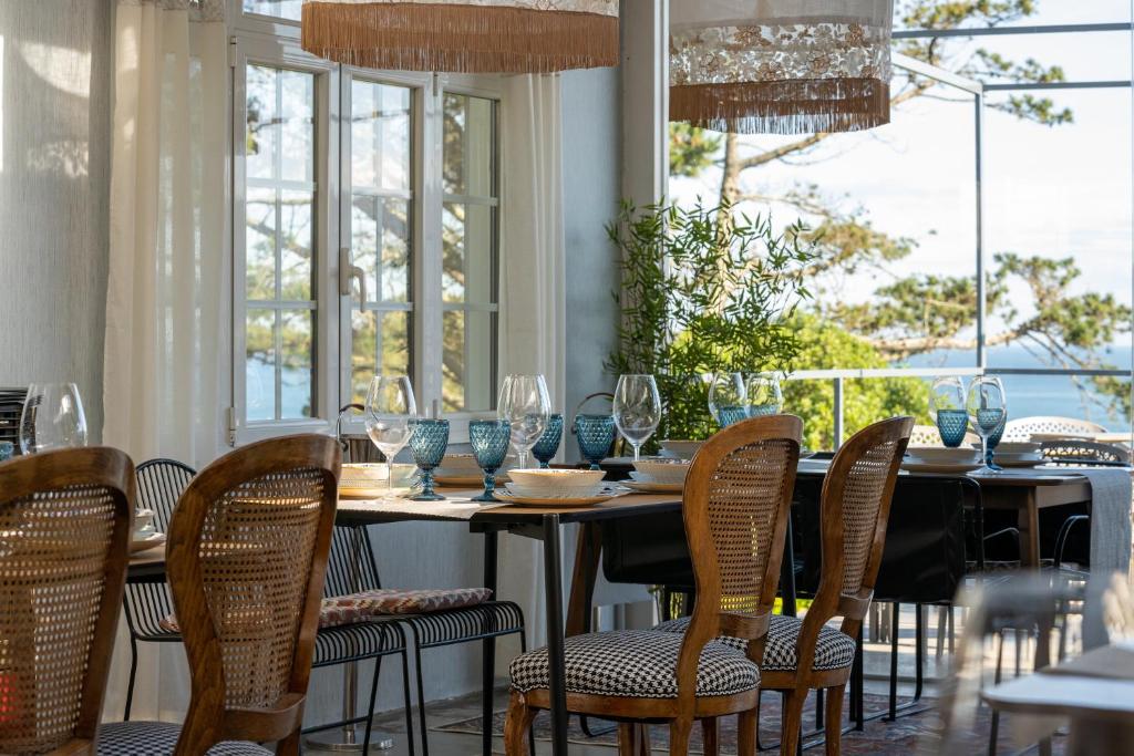 una sala da pranzo con tavolo, sedie e finestre di finca dos Mares a Ferrol
