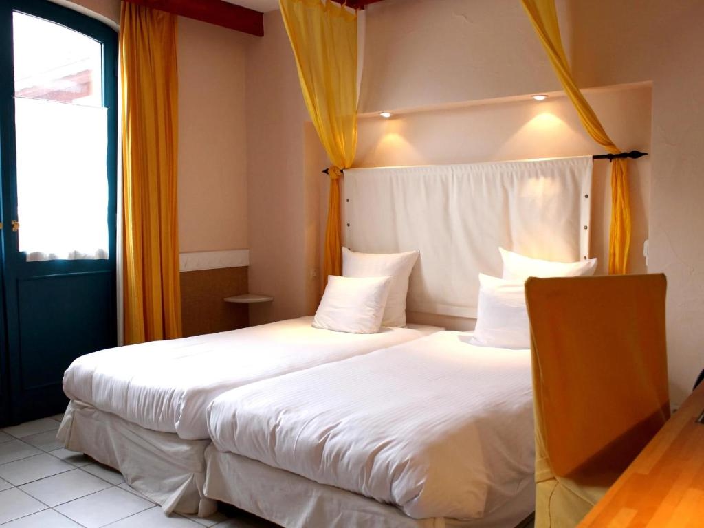 Ein Bett oder Betten in einem Zimmer der Unterkunft Logis Hôtel Les Pages