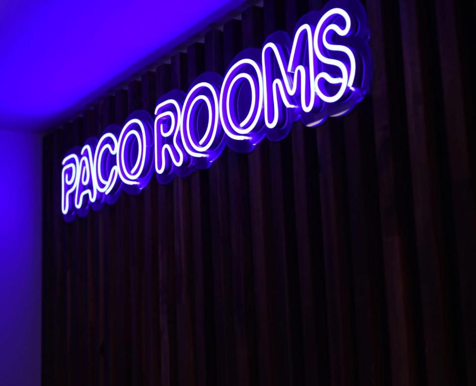 a neon sign that reads paso robles on a curtain at PACOROOMS in Madrid