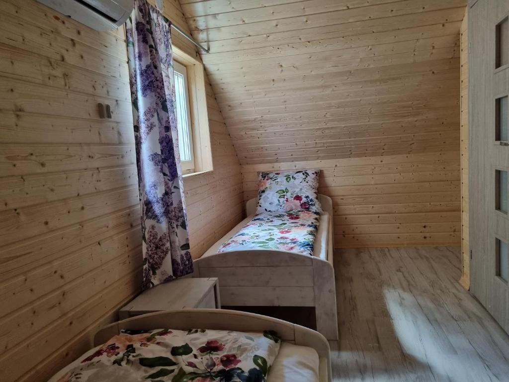 mały pokój z dwoma łóżkami i oknem w obiekcie Kwiatowe Domki w Rogowie