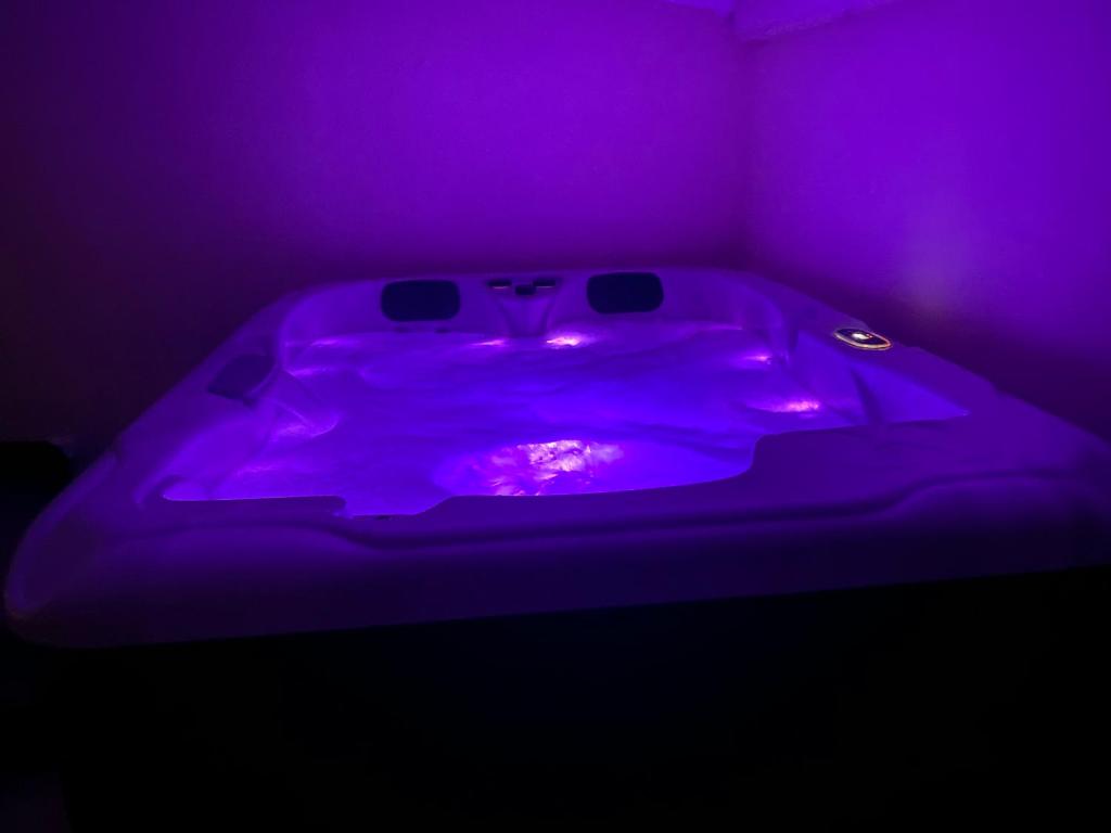 a purple bathtub with a purple light in a room at Casa Melodia in Pontoise
