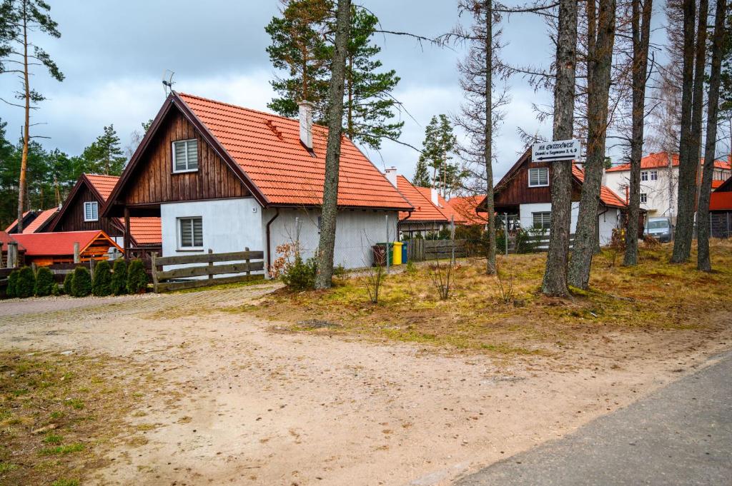 una casa con techo naranja y un camino de tierra en Domek na Kaszubach na Gwizdowce, en Załakowo