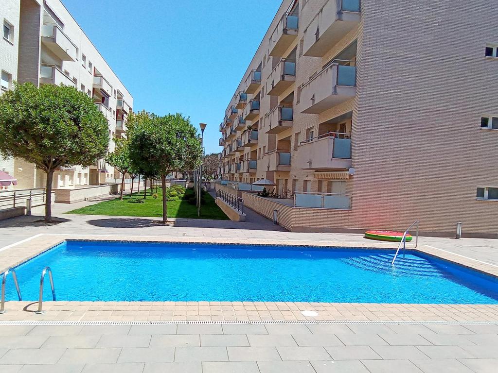 einem Pool vor einem Apartmentgebäude in der Unterkunft ENJOY your HOLIDAYS with us !!, TERRACE 25m2 - Apartment 65m2 3 Bedrooms, Capacity 4-6pers, WIFI, IDEAL to DIGITAL NOMAD Beach 5min walking, 4 Pools, Parking Opt, Air Conditioning in Lloret de Mar