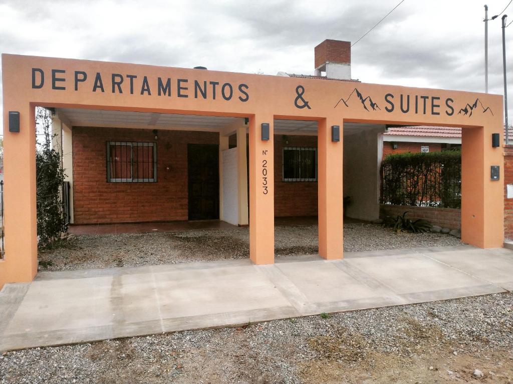 een gebouw met een bord dat afdelingen en suites leest bij Sierras Alojamiento in Mina Clavero