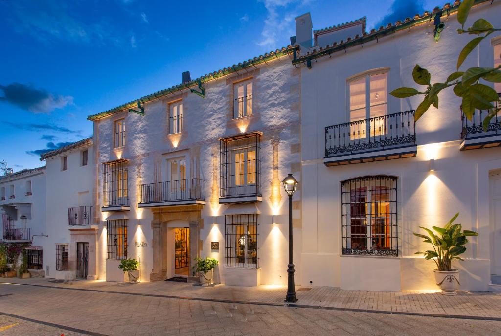 a white building with a street light in front of it at La Fonda Heritage Hotel Luxury, Relais & Châteaux in Marbella