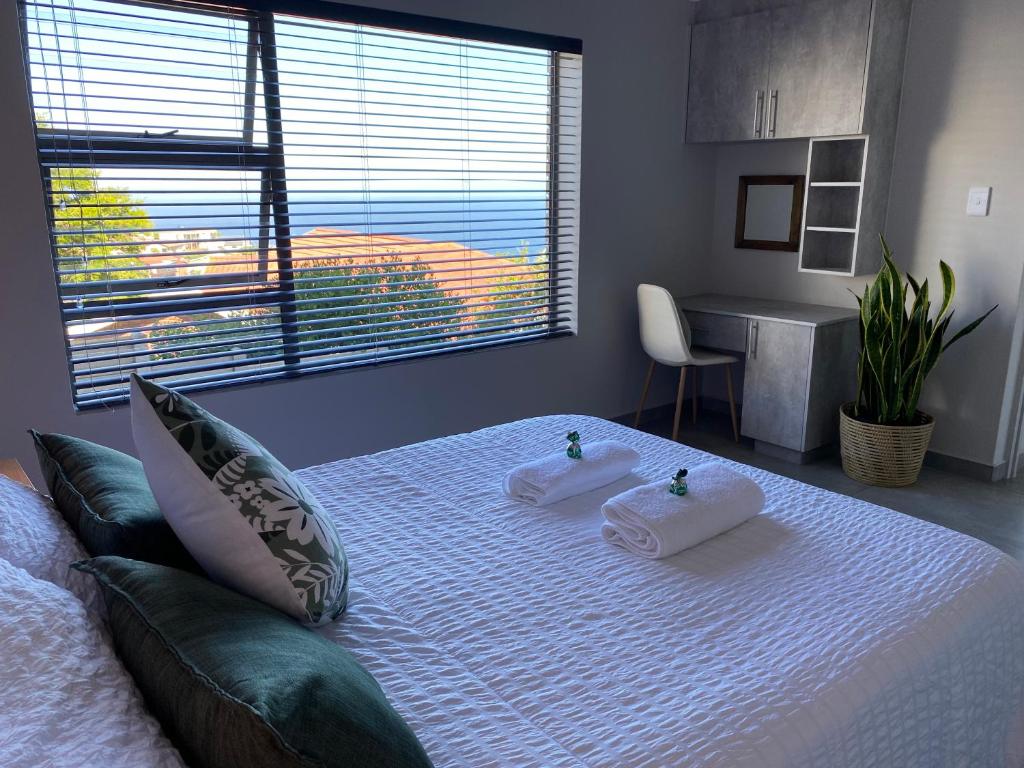 1 dormitorio con 1 cama con 2 toallas en Tulip On The Bay en Mossel Bay