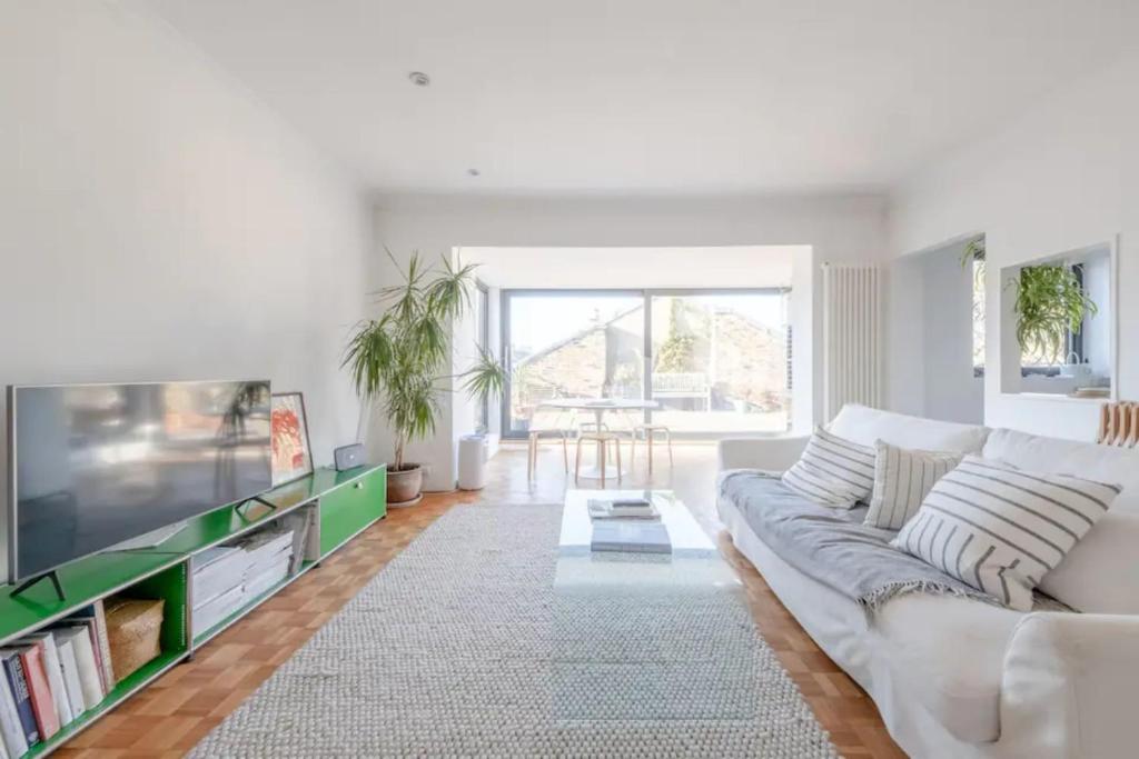 a living room with a couch and a tv at Peaceful 2 Bedroom Flat with Roof Terrace - Hackney in London