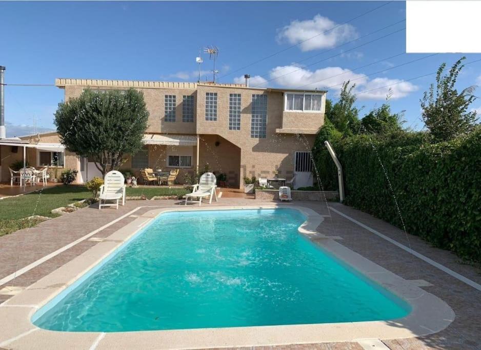 una piscina frente a una casa en Planta superior independiente con piscina - barbacoa, 