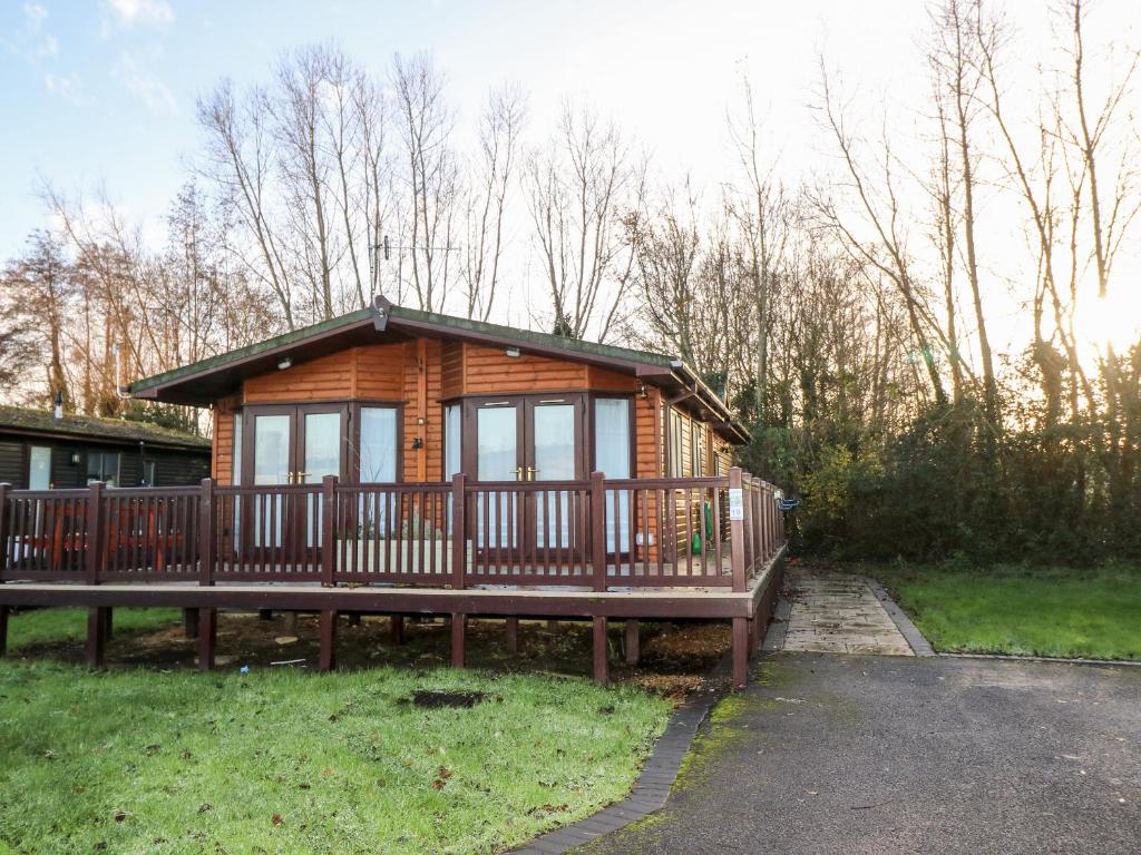 a large wooden cabin with a large deck at The Goodwood Annex in Chichester