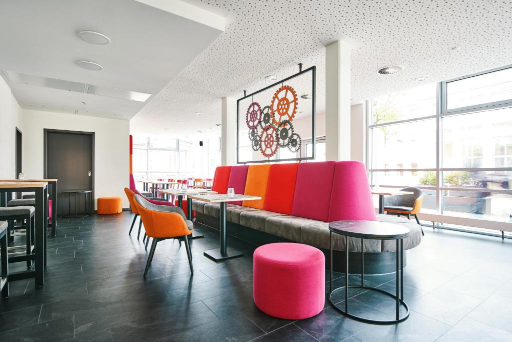 a restaurant with a couch and tables and chairs at Bielefeld JBB Jugendgästehaus in Bielefeld