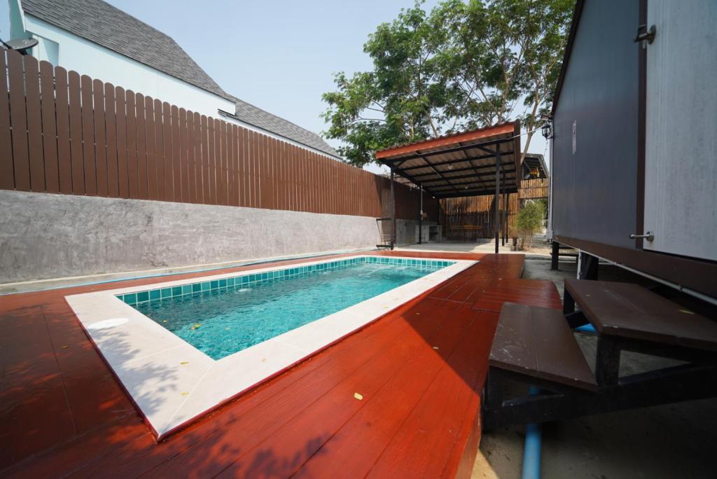 - une piscine sur du parquet à côté d'un bâtiment dans l'établissement Ban Ta Yay Pool Villa Suanphueng, à Suan Phueng