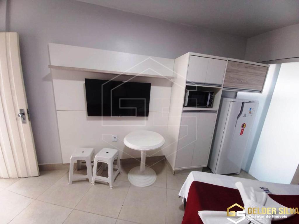 a small kitchen with a table and two stools at CTC Araras Centro in Caldas Novas