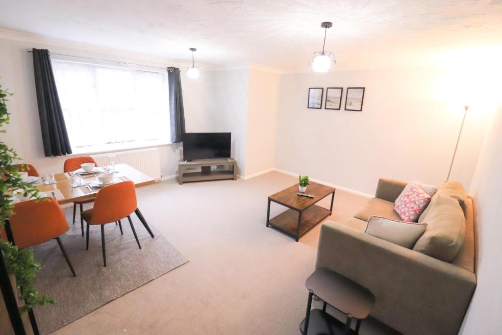 a living room with a couch and a table at Chic 2BR Flat in Bishop's Stortford in Bishops Stortford