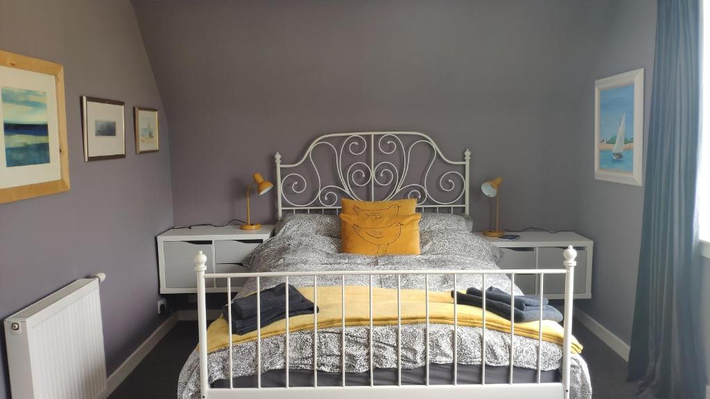 um quarto com uma cama com uma almofada amarela em Chilowen - Happy House em Inverkeithing