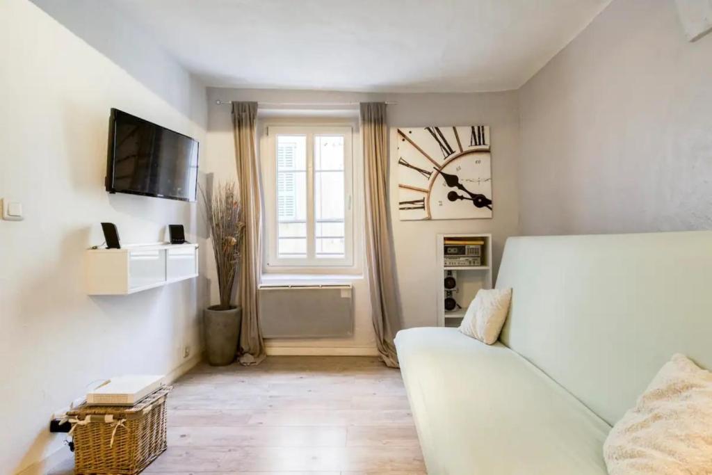 a living room with a white couch and a window at Sun Studio in Valbonne