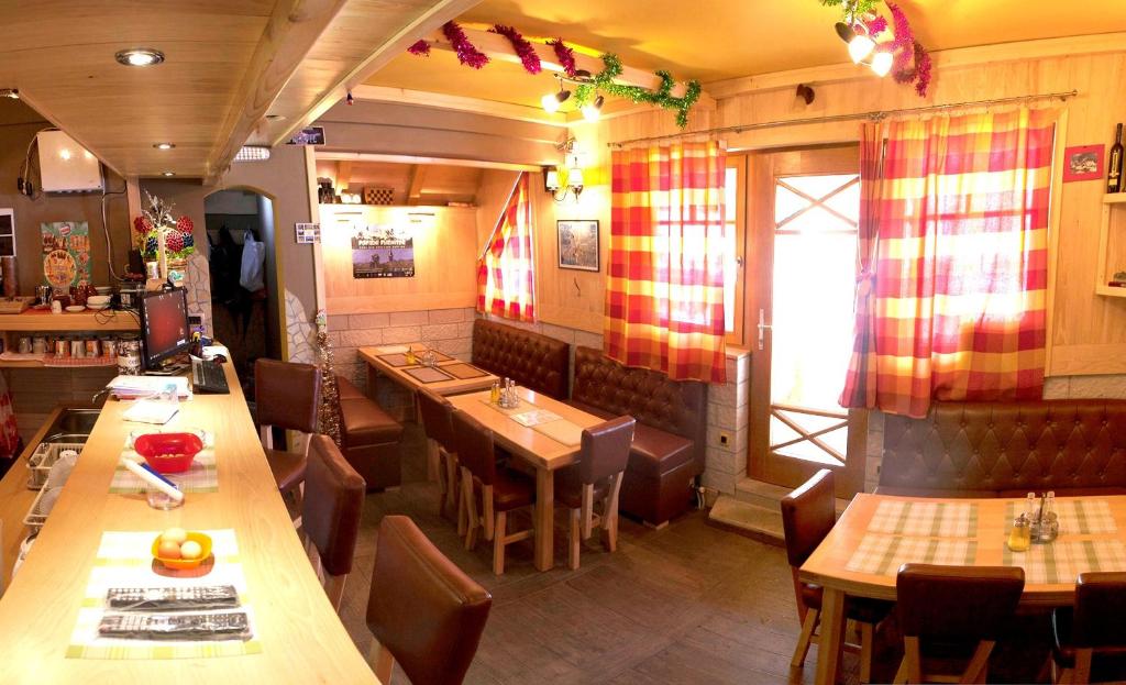 un restaurante con mesas de madera y sillas en una habitación en Žabljak City Center Apartments, en Žabljak