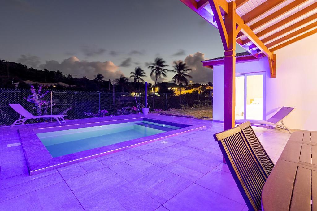 einen Pool im Hinterhof mit lila Beleuchtung in der Unterkunft villa de prestige Anse ka'nel in Le Moule