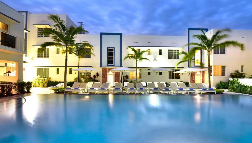 a swimming pool with chairs and a building at Pestana South Beach Hotel in Miami Beach