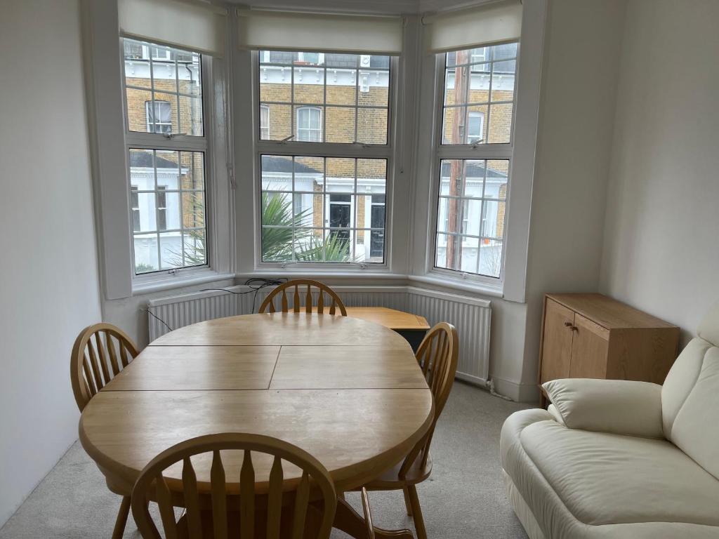 a living room with a table and chairs and a couch at Spacious 3 Bed Flat in Greenwich in London