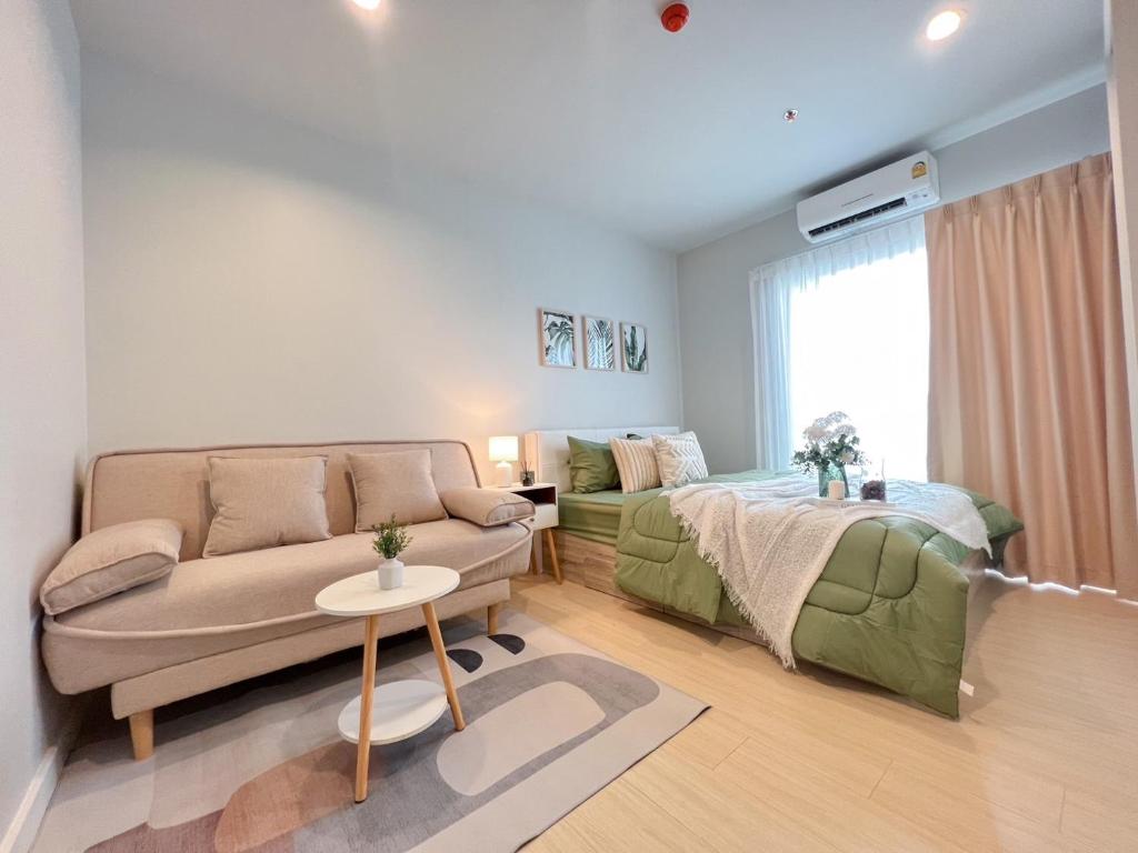 Condo-Wutthakard في بانكوك: غرفة معيشة مع أريكة وسرير