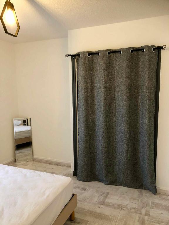 a bedroom with a shower curtain and a bed at Auberge Les Grillons in Meyras