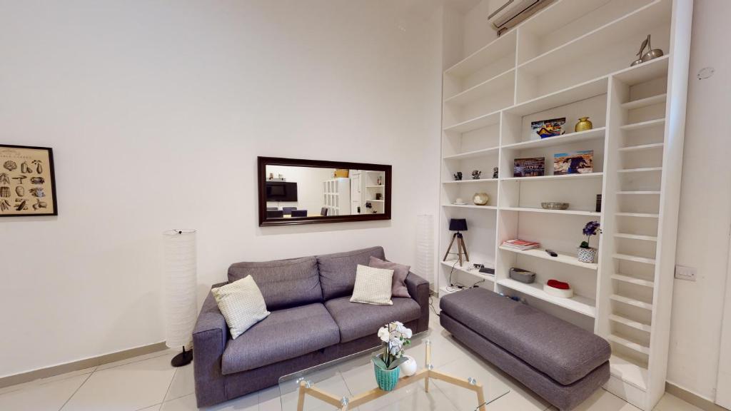 a living room with a couch and shelves at Spacious 3 bedroom maisonette in Sliema