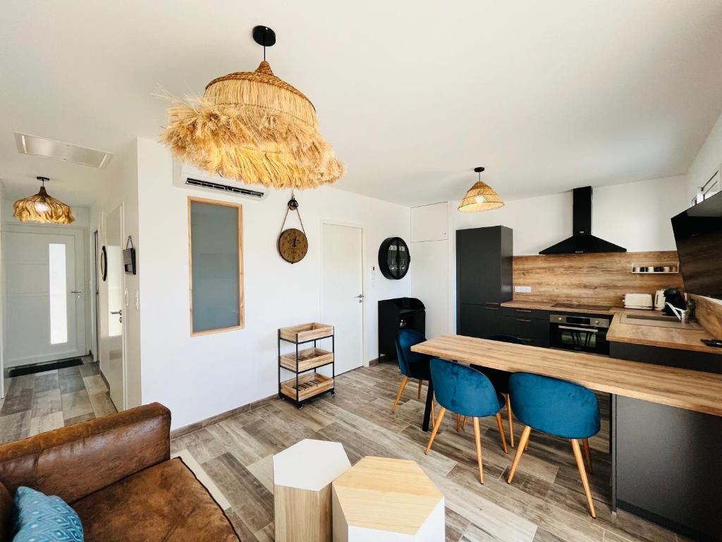 - un salon avec une table et des chaises bleues dans l'établissement Maison forestière, mer & lumière, à Saint-Jean-de-Monts
