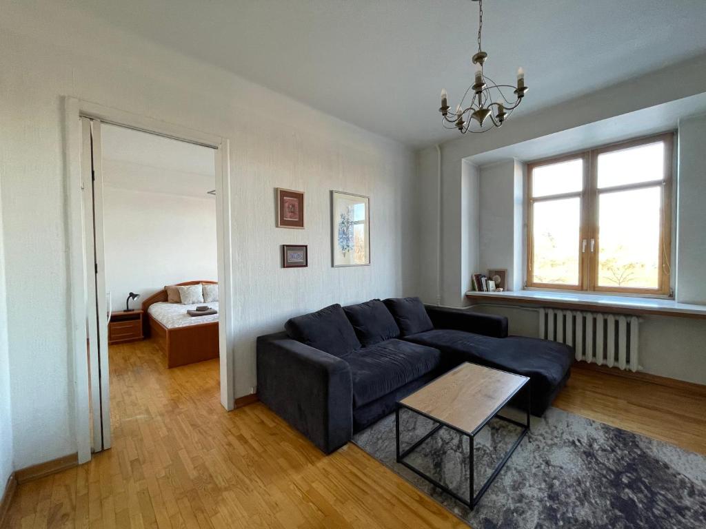 uma sala de estar com um sofá azul e uma mesa em A cozy apartment with a wonderful view of the river in the old town of Vilnius em Vilnius