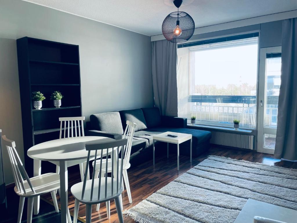 uma sala de estar com uma mesa e um sofá em Tapiola Center Apartment em Espoo