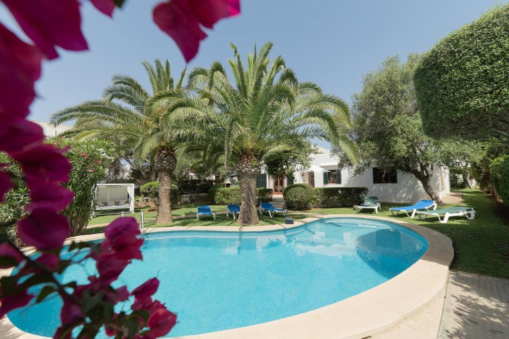 una piscina en un patio con palmeras en Villa Dora en Cala d´Or