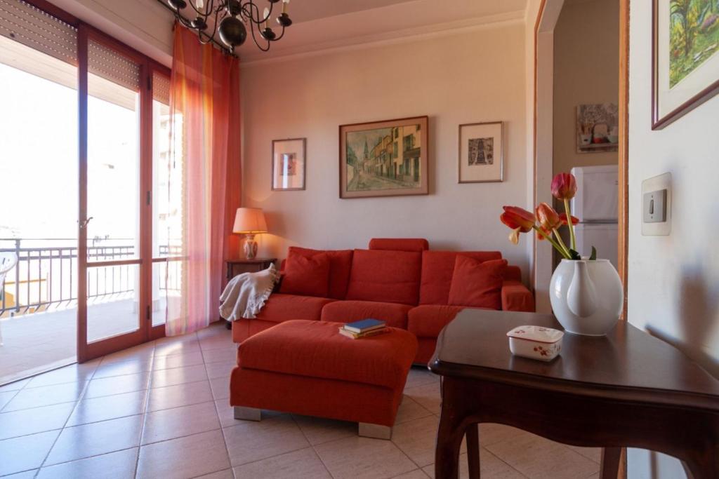 - un salon avec un canapé rouge et une table dans l'établissement Appartamento TL, à Follonica